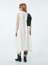 Vestido blanco con escote en V, cuello camisero y corte asimétrico.