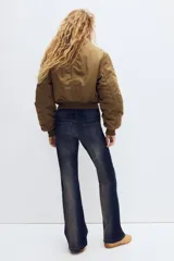 Jean de corte acampanado y tiro ultra bajo en denim azul oscuro con efecto desteñido y leve elasticidad.