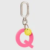 Llavero con dije en forma de letra A color rosado y pequeño dije circular amarillo con logo de la marca grabado. Incluye gancho metálico tipo mosquetón.