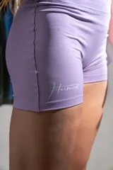 Calza deportiva corta color lila con tiro alto y logo de la marca en el muslo.