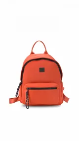 Mochila de neopreno color marrón claro, con diseño compacto y moderno. Cuenta con un compartimento principal con cierre, un bolsillo frontal con cierre y tiradores de cordón trenzado en blanco y negro. Incluye asa superior, correas regulables y un bolsillo trasero con cierre vertical.