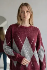 Sweater de tejido de punto con diseño de rombos en contraste, cuello redondo y mangas largas. Presenta una textura suave y un corte holgado.