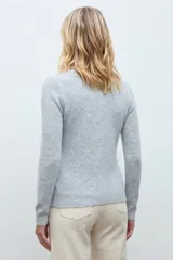 Cardigan de punto color gris melange con cuello redondo, cierre frontal de botones y delicado bordado floral en color blanco en la parte frontal.