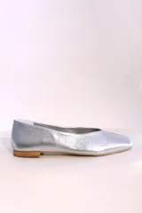 Ballerinas doradas con punta redondeada y suela plana color madera.