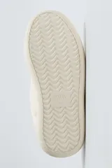 Zapatillas deportivas color crema, de cuero sintético, con cordones y suela de goma gruesa.