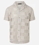 Camisa de manga corta con cuello inglés y abotonadura frontal. Diseño con encaje bicolor texturizado en tonos beige y blanco. Corte regular.