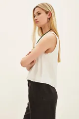 Top negro de poliéster con escote en V, tirantes con detalle de encaje y corte holgado.