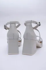 Sandalias de cuero color cobre con plataforma y taco cuadrado. Tiras cruzadas sobre el empeine y pulsera con hebilla al tobillo.