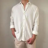 Camisa de lino manga larga color blanco, con cuello camisero clásico y cierre frontal de botones.