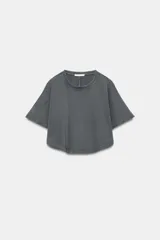 Top crop gris oscuro con efecto lavado, confeccionado en algodón, con cuello redondo y mangas cortas amplias.