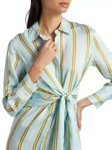 Vestido camisero midi celeste con rayas verticales blancas y amarillas, de manga larga con puños abotonados y lazo ajustable en la cintura.