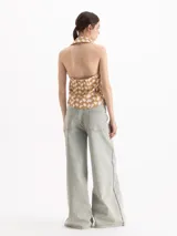 Pantalon de denim tiro medio color gris, con diseño amplio y costuras decorativas frontales. Cuenta con pasacintos, bolsillos y cierre frontal con botón.