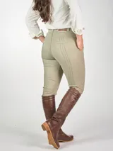 Pantalón chupín de gabardina elastizada color azul petróleo, tiro alto, con alforzas en delantero y trasero, pretina ancha con doble botón, bolsillos traseros falsos y terminación de bajo con puño y botón.