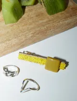 Set de dos broches para el pelo con base metálica plateada y apliques de mostacillas amarillas y pieza central cuadrada color mostaza.