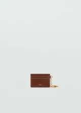 Porta documentos y tarjetero de poliuretano efecto piel color marrón, con múltiples ranuras para tarjetas, costuras decorativas contrastantes, logo metálico dorado en la parte frontal y llavero con cadena y argolla dorada.