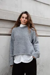 Buzo tejido en mohair de corte crop, con cuello redondo y tajos laterales. Diseño holgado con mangas largas.