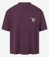 Remera boxy de algodón desteñido color lila, de corte holgado, cuello redondo y manga corta. Cuenta con un pequeño estampado floral en el pecho y un diseño más grande en la espalda.