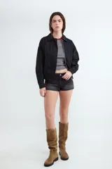 Campera bomber negra de algodón con cuello solapa, cierre frontal con cremallera y corte recto.