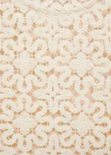 Vestido corto de crochet con diseño de flores, cuello redondo y corte recto. Cuenta con forro interior y diseño sin mangas.