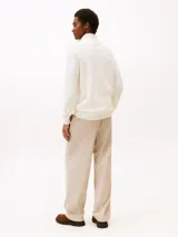 Sweater de punto color blanco marfil de la marca Tommy Hilfiger, con cuello perkins y cierre frontal parcial de cremallera. Presenta mangas largas con puños de canalé y el logo bordado en el pecho.