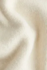 Buzo de punto suave con cuello tipo polo, mangas raglán y terminaciones acanaladas en puños y bajo.