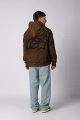 Buzo canguro oversize con efecto lavado desgastado, confeccionado en friza pesada. Presenta diseño con recortes, capucha amplia y puños y ruedo acanalados.