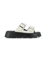 Sandalia de cuero graneado color blanco off-white, con suela chunky negra de poliuretano y doble tira ajustable con hebillas metálicas.