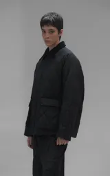 Campera oversize de microfibra opaca con diseño matelaseado de rombos. Presenta cuello de corderoy a tono, cierre frontal metálico y dos amplios bolsillos delanteros con solapa y broche snap. Interior forrado y relleno con guata térmica.