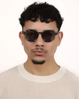 Lentes de sol cuadrados con montura verde oliva y lentes grises.