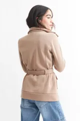 Tapado negro de poliéster con cuello solapa, doble botonadura, cinturón y bolsillos laterales.