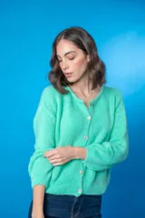 Cardigan tejido color verde agua, con cuello redondo, cierre frontal con botones y mangas largas.