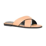 Sandalias bajas color piel con tiras anchas cruzadas y suela negra.