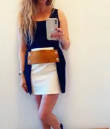 Minifalda blanca con aplique de cuero marrón con botones plateados.