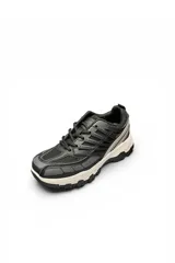 Zapatilla deportiva chunky color blanco con detalles en gris, suela gruesa texturizada y diseño de malla y capas superpuestas.