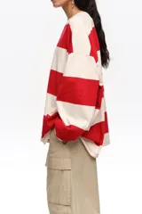 Remera manga larga oversize con diseño de rayas horizontales anchas rojas y blancas, cuello redondo y calce holgado.