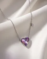 Collar de plata con cadena fina y dije en forma de corazón de cristal violeta tornasolado, acompañado de un pequeño detalle de cristal brillante en la cadena.
