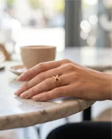 Anillo de acero con baño de oro rosa, con diseño central en forma de símbolo de infinito.