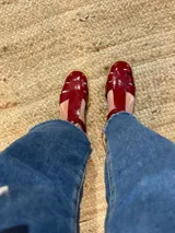 Sandalias rojas de cuero con tiras anchas y hebilla al tobillo.