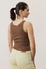 Musculosa de tejido rib color beige con detalles marrones en los bordes del cuello y sisas. Cuenta con el logotipo de la marca bordado en el pecho.