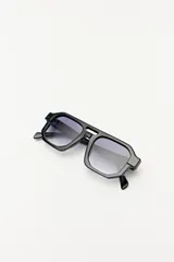 Lentes de sol con marco geométrico negro y lentes con degradé azul.