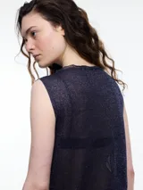 Musculosa de tejido fino y translúcido con sutil brillo metálico, de corte relajado, sin mangas y largo por debajo de la cadera con aberturas laterales.