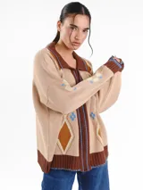 Campera tejida en jacquard con cierre frontal, cuello tipo polo y bolsillos delanteros. Diseño multicolor con estampado geométrico de rombos y detalles bordados a mano.