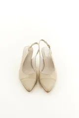 Zapatos slingback de cuero color beige con punta fina, taco medio y tira ajustable en el talón.