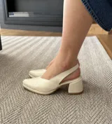 Sandalias de cuero color crema con taco bloque y tira trasera.