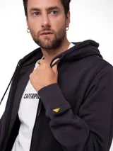 Buzo con cierre frontal completo, confeccionado en tejido fleece color negro. Presenta capucha forrada, bolsillos tipo canguro con entrada lateral, puños y cintura acanalados, y etiqueta con logo de la marca en el bajo.