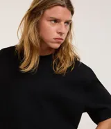 Remera de corte oversize color marrón, con cuello redondo, mangas cortas y sisa desplazada. Diseño liso sin estampados.