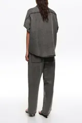 Pantalón de denim color negro con efecto acid wash, corte recto y holgado, de tiro medio con cintura elástica.
