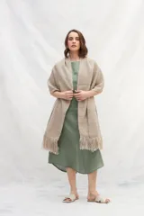 Chal de lana sin teñir en color marrón, con diseño tejido y terminaciones en flecos en los extremos.