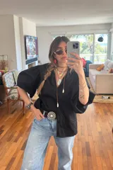 Camisa negra de poplin, corte amplio con mangas abullonadas y botones a tono.