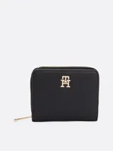 Billetera Tommy Hilfiger negra con acabado granulado, cierre de cremallera y solapa con botón a presión. Incluye compartimento interior para billetes y múltiples ranuras para tarjetas.